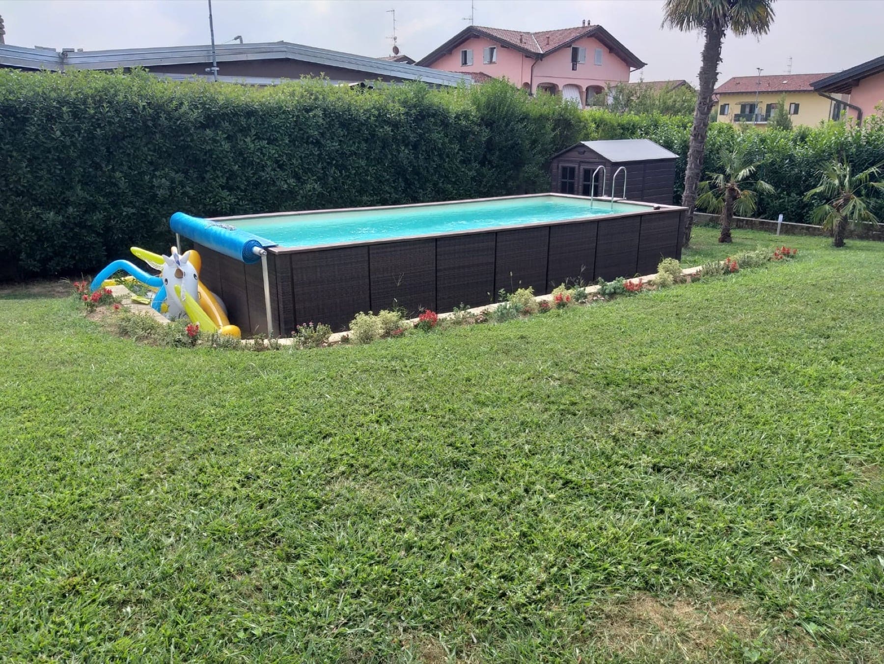 Piscina fuori terra con copertura estiva su rullo appoggiato a piantane
